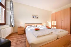 una camera da letto con un grande letto con lenzuola bianche di Villa Lamora 02 a Heringsdorf