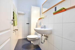 een witte badkamer met een toilet en een wastafel bij Villa Lamora 03 in Heringsdorf