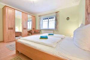Schlafzimmer mit einem großen weißen Bett und einem Fenster in der Unterkunft Haus am Schloonsee 03 in Bansin