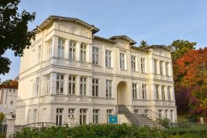 ein großes weißes Gebäude mit einer Treppe davor in der Unterkunft (61c) Villa Meeresblick 3 in Ahlbeck