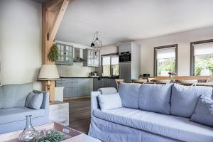 a living room with a blue couch and a kitchen at Gieters Geluk in Giethoorn