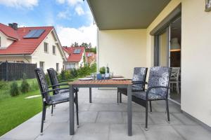 un patio con mesa de madera y sillas en Sonnenpark 12, en Korswandt