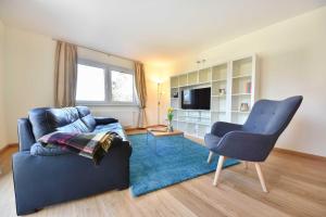 ein Wohnzimmer mit einem blauen Sofa und einem Sessel in der Unterkunft Haus Neuhof 01 in Heringsdorf