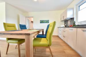 eine Küche mit einem Holztisch und grünen Stühlen in der Unterkunft Haus Neuhof 01 in Heringsdorf