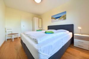 ein großes weißes Bett in einem Zimmer mit einem Tisch in der Unterkunft Haus Neuhof 01 in Heringsdorf