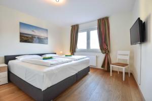 ein Schlafzimmer mit großem Bett und Fernseher in der Unterkunft Haus Neuhof 01 in Heringsdorf