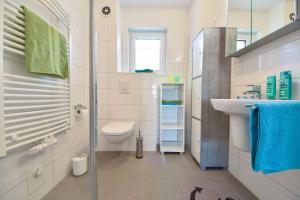 ein weißes Badezimmer mit Toilette und Waschbecken in der Unterkunft Haus Neuhof 01 in Heringsdorf + 7 Fotos