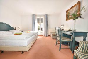 ヘリングスドルフにあるVilla Hohe Düne 01のベッドルーム1室(ベッド1台、デスク、椅子付)