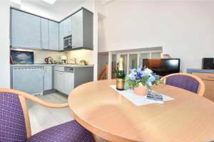 ヘリングスドルフにあるVilla Hohe Düne 08のキッチン、ダイニングルーム(木製テーブル、紫色の椅子付)