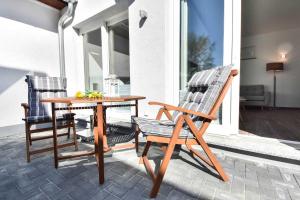 a patio with a table and two chairs on a porch at Kleines Ferienhaus Kuschelnest in Kamminke