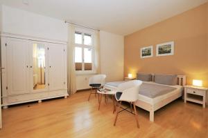 een slaapkamer met een bed en een tafel en stoelen bij Villa Luna Wohnung 9 in Ahlbeck