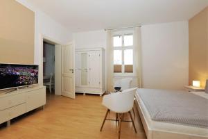 een witte slaapkamer met een bed en een televisie bij Villa Luna Wohnung 9 in Ahlbeck