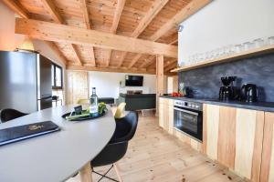 una cucina con piano di lavoro bianco e soffitti in legno di Sonnenlauf Wohnung Ost a Bansin