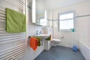 ein weißes Badezimmer mit Waschbecken und Toilette in der Unterkunft Ferienwohnung Elunia in Heringsdorf