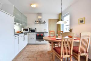 eine Küche mit einem Tisch und Stühlen in einer Küche in der Unterkunft Ferienwohnung Elunia in Heringsdorf + 12 Fotos