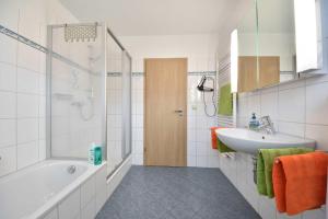 ein weißes Badezimmer mit Badewanne und Waschbecken in der Unterkunft Ferienwohnung Elunia in Heringsdorf