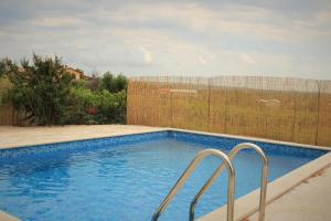 a swimming pool with two metal rails next to a fence at Apartman Robi in Nova Vas