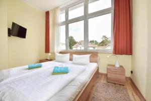 ein Schlafzimmer mit einem großen Bett mit Fenster in der Unterkunft (27a) Villa Seestern 05 in Heringsdorf