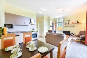 eine Küche und ein Wohnzimmer mit Tisch und Stühlen in der Unterkunft (27a) Villa Seestern 05 in Heringsdorf