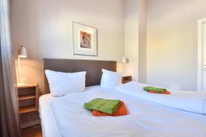 2 Betten in einem Hotelzimmer mit Handtüchern darauf in der Unterkunft Gartenhaus Ostseevilla 07 in Bansin