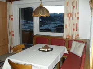 ein Esszimmer mit einem Tisch und einem Fenster in der Unterkunft Haus Schellenschmied in Pettneu am Arlberg