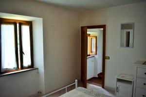 an empty room with two windows and a bathroom at Casa Titina Riposo e Relax nella campagna toscana in Pratovecchio