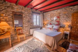 a bedroom with a bed and a stone wall at Txerturi-Goikoa in Itziar