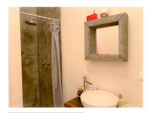 bagno con doccia, lavandino e specchio di kunst@funf a Grado
