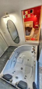 eine große weiße Badewanne in einem Zimmer mit Spiegel in der Unterkunft Casa Crown in Braşov