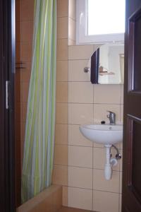 a bathroom with a sink and a shower curtain at Apartamenty i pokoje Skrzypkowscy.pl in Karwia