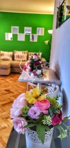 un jarrón con flores sobre una mesa en la sala de estar en Casa Crown en Braşov