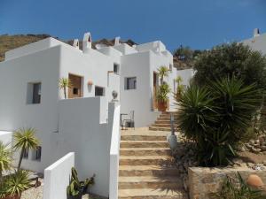 a white house with stairs and palm trees at En la Majada Redonda in Presillas Bajas