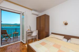 a bedroom with a bed and a desk and a balcony at Bace Apartments in Klek