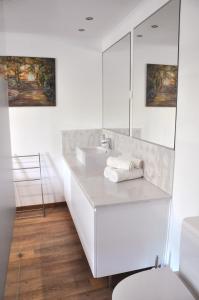 uma casa de banho branca com um lavatório e um espelho em Sleep In Bucelas em Bucelas