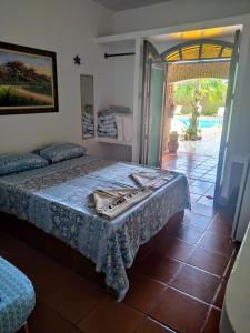 Schlafzimmer mit einem Bett und einer Tür zu einer Terrasse in der Unterkunft Pousada Na Praia Ubatuba in Ubatuba