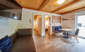 a living room with a table and a couch at Delfi Ski & Bike Appartements in Saalbach-Hinterglemm