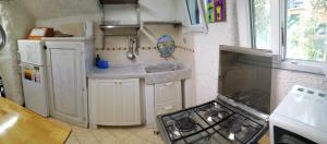 een kleine keuken met een fornuis en een wastafel bij APPARTAMENTO CON GIARDINO, TERRAZZO e GARAGE A DUE PASSI DAL MARE e DALLE CINQUETERRE in Levanto +19 foto's