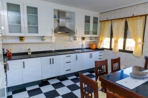 cocina con armarios blancos y suelo a cuadros en CampoFontal apartamento, en Boiro