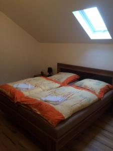 a large bed in a bedroom with a skylight at Pension Lefebvre in Weil am Rhein