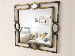 einen Spiegel, der in einem Schlafzimmer an einer Wand hängt in der Unterkunft Aveiro, Ria e Arte in Aveiro