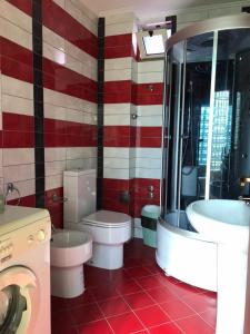 a red and white bathroom with a toilet and a sink at Hotel Durres Vila 53 in Durrës