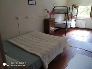 Stone Farm Hostel في فيلجويراس: غرفة نوم مع سرير وسرير بطابقين