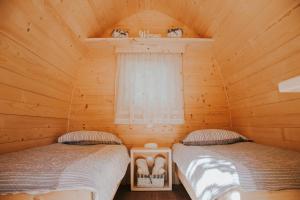 two beds in a log cabin with a window at TOP rafting center in Bovec