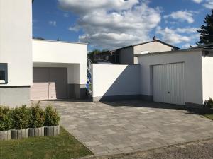 ein weißes Haus mit Auffahrt und Garage in der Unterkunft Ferienhaus Nahe der Ostsee in Bad Doberan