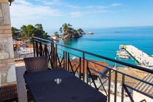 a table on a balcony with a view of the ocean at Petros Penthouse in Parga