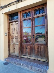 eine Holztür mit Fenstern auf einem Gebäude in der Unterkunft Apartamento Torreón de la Bombardera in Teruel