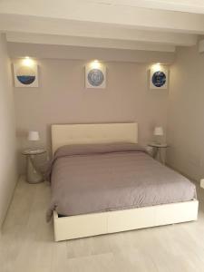 ein Schlafzimmer mit einem großen Bett mit zwei Tischen in der Unterkunft Casa Bolle Ortigia in Syrakus