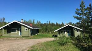 Lomamökit Saimaanranta Suur-Saimaa Strand Resort Oy في Taipalsaari: مبنيان صغيران يجلسان بجوار طريق ترابي