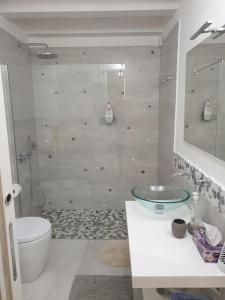 ein Badezimmer mit einem Glaswaschbecken und einem WC in der Unterkunft Casa Bolle Ortigia in Syrakus
