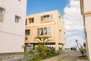 a yellow building next to a white building at GUEST HOUSE SORA 2 in Okinawa City